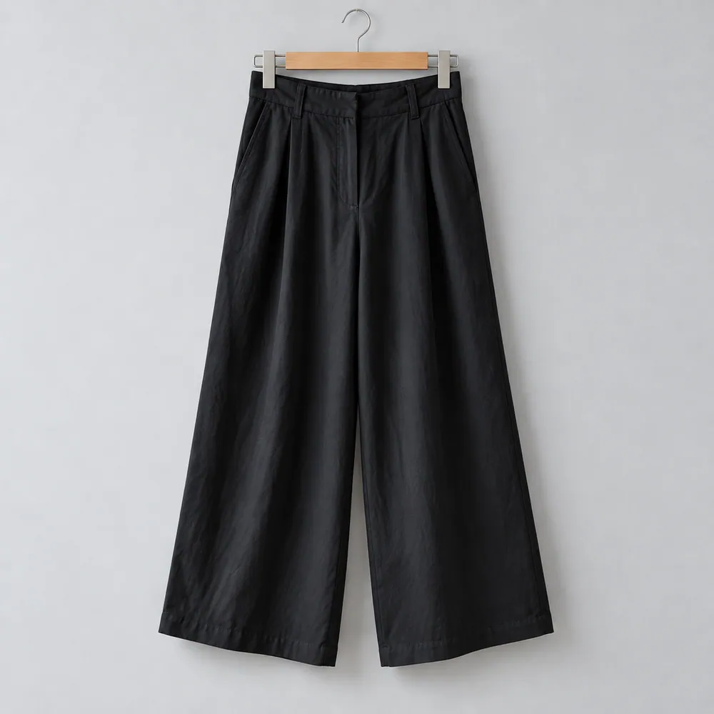 Pantalón Bruma negro de pierna amplia y pinzas, en una percha