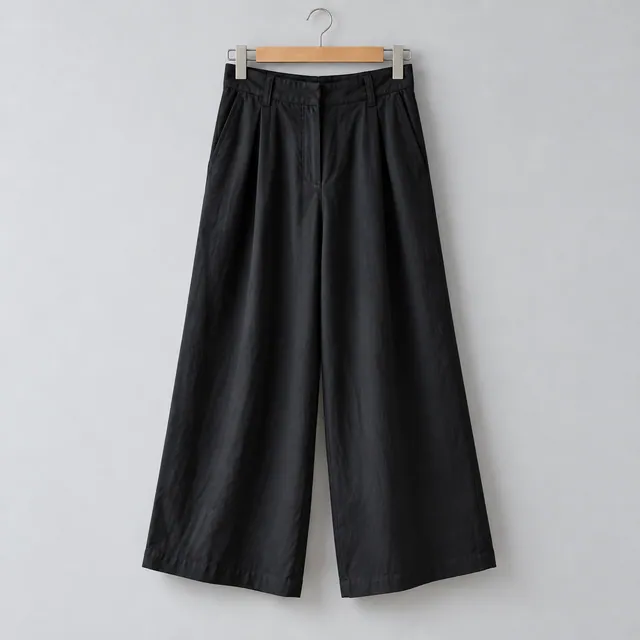 Pantalón Bruma negro de pierna amplia y pinzas, en una percha